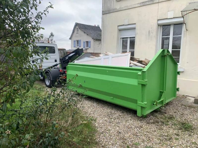 Benne verte livrée devant une maison