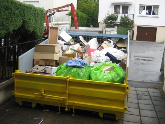 Benne jaune remplie d'encombrants chez un particulier